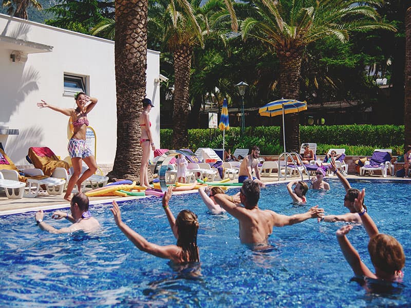 Spoljni bazen u Hotel Montenegro sa vodenim aerobikom i animacijom, palmama i ležaljkama oko bazena