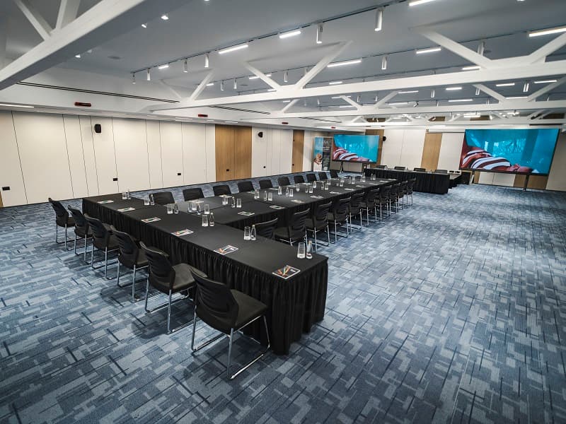 Konferencijska sala u Hotel Tara u U-rasporedu sa bočnim pogledom zdesna, ekranom u pozadini i drvenim panelima na zidovima