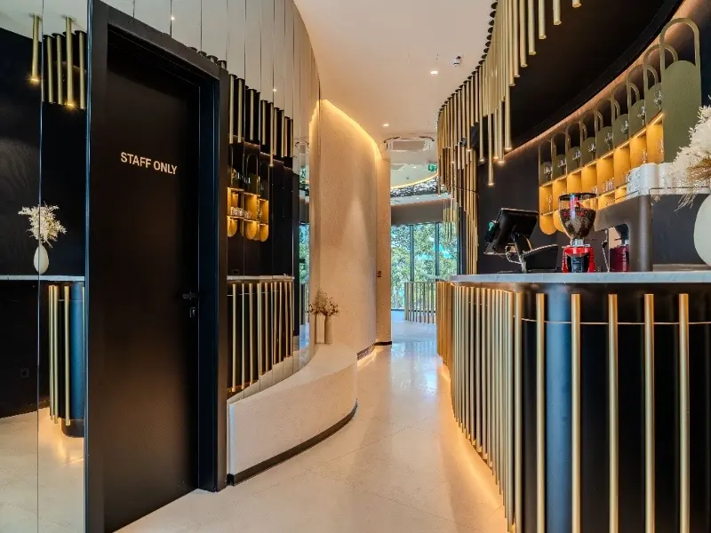 Bar i recepcija event centra hotela Pinija sa crno-zlatnim enterijerom i modernim dizajnom