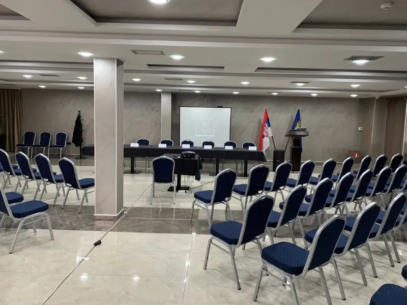 Kongresna sala u Hotel Vrnjačke Terme sa predsedničkim stolom, projekcionim platnom, zastavama Srbije i EU, govornicom i plavim stolicama u pozorišnom rasporedu