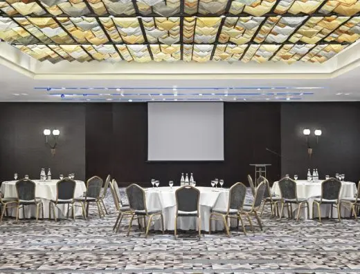 Velika balna sala u Metropol Palace Hotel sa okruglim stolovima, projektorskim platnom, dekorativnim plafonom sa zlatnim elementima i geometrijskim tepihom