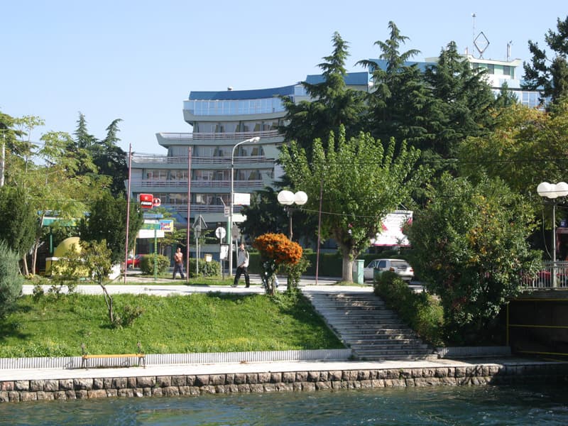 Eksterijer Hotel Drim sa moderne fasade, staklenim elementima, zelenim parkom, stepeništem i pogledom sa obale jezera