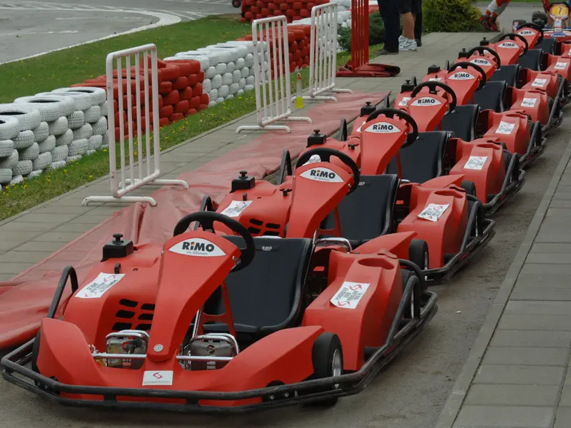 Red crvenih Rimo karting vozila u Autokomerc Karting Centar parkiran pored staze sa gumama i zaštitnim ogradama