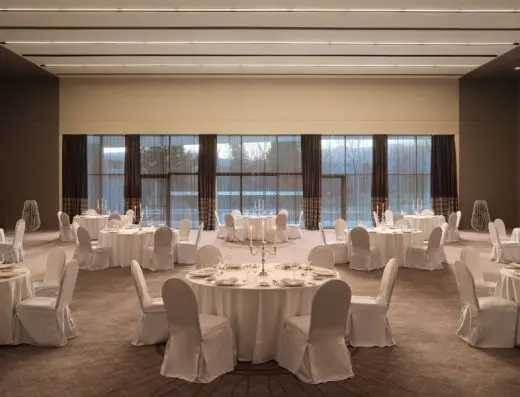 Banket sala u hotelu Sheraton Dubrovnik Riviera Hotel sa okruglim stolovima, belim navlakama za stolice, svećnjacima i velikim prozorima