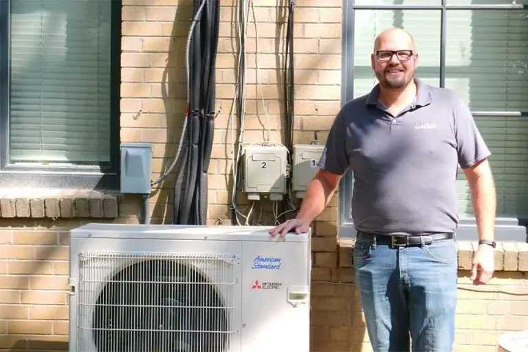 hvac system types worker standing next to the unit