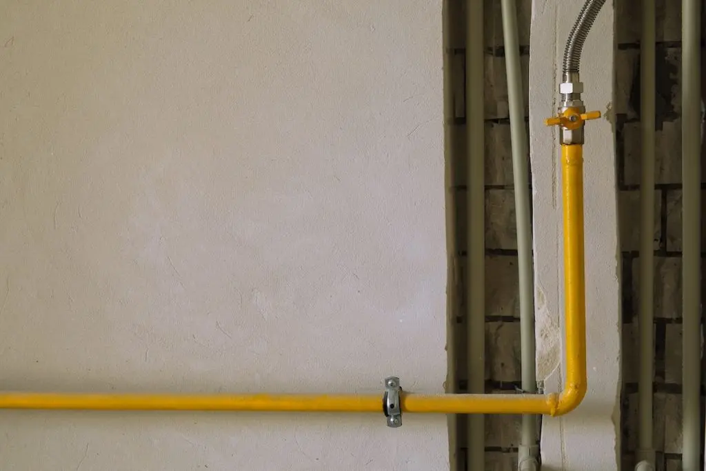 Yellow gas pipe on residential house wall. Indoor gas pipeline