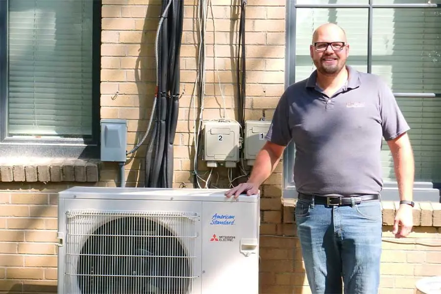 hvac system types worker standing next to the unit