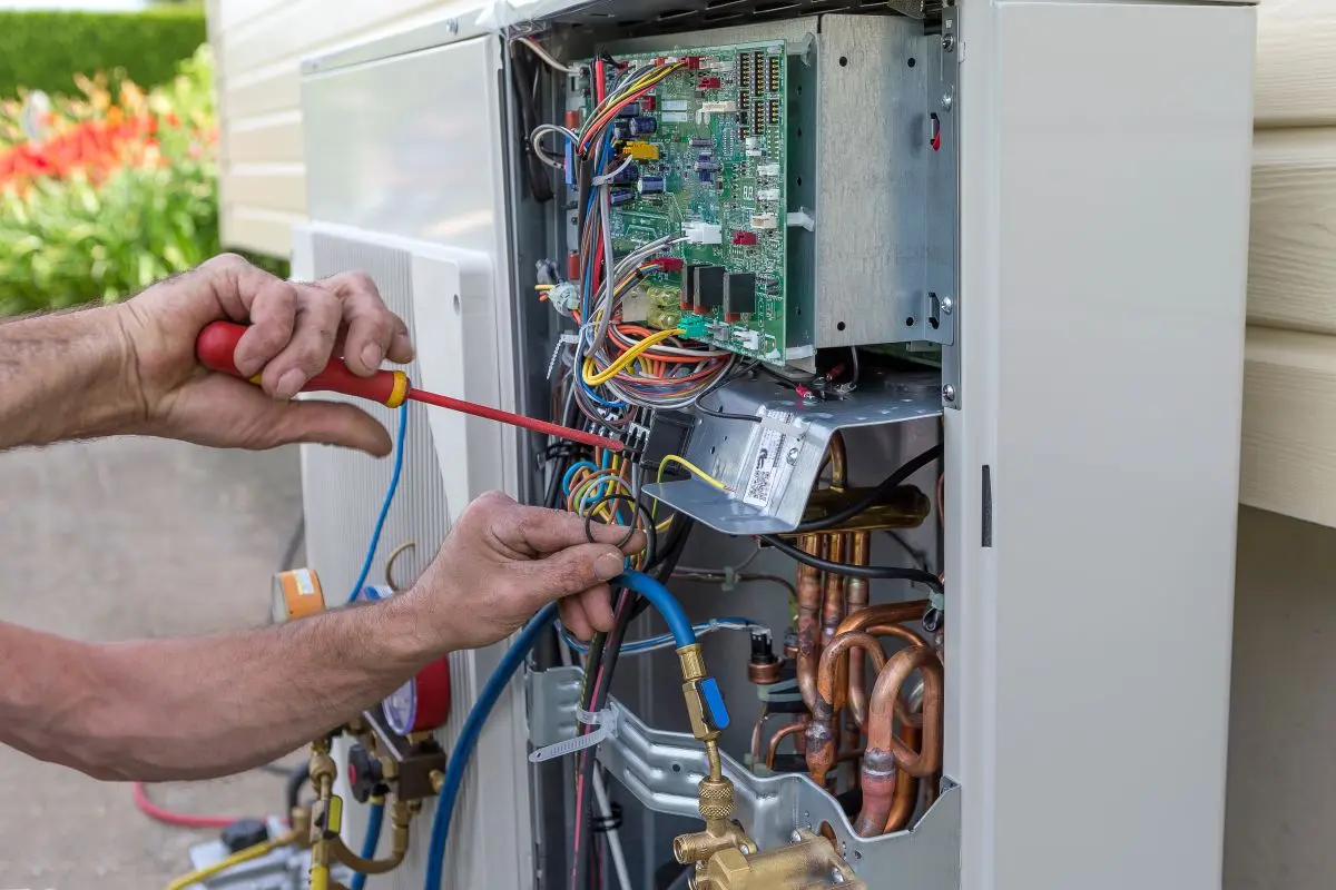 heat pump installation guy using screwdriver on wires