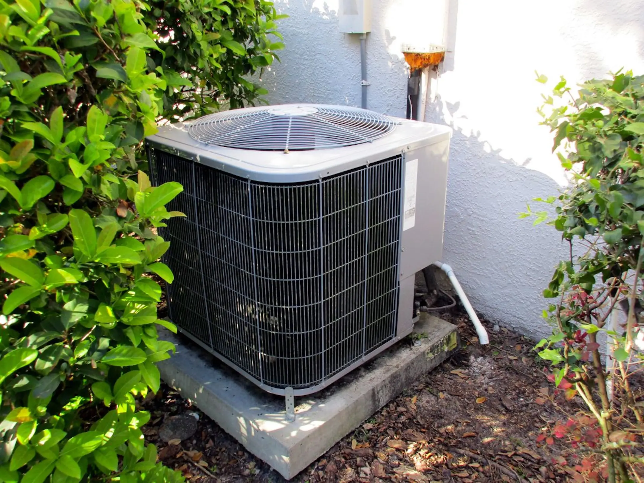 Air-Conditioning-Unit-On-Side-of-Florida-House-with-Green-Bushes