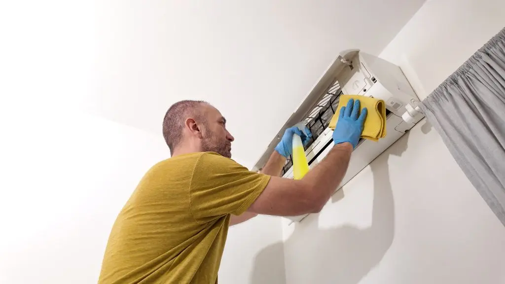 ac freezing up Man cleaning and maintaining air condition unit at Man cleaning and maintaining air condition unit at home.