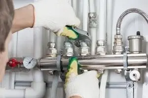 Person Working on Pipes with a Wrench
