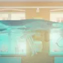 Flooded bathroom interior with water covering fixtures, illustrating plumbing emergencies and the need for professional assistance.