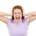 A woman with a distressed expression holds her hands over her ears, conveying anxiety about HVAC issues.