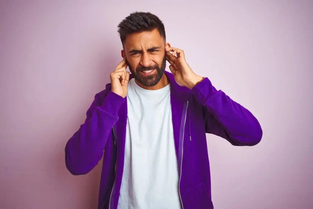 man covering his ears