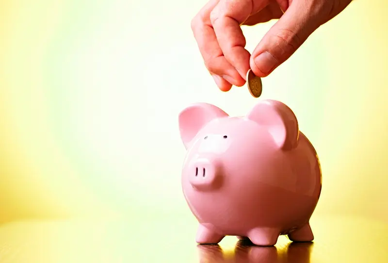 Man paying in money into a piggy bank