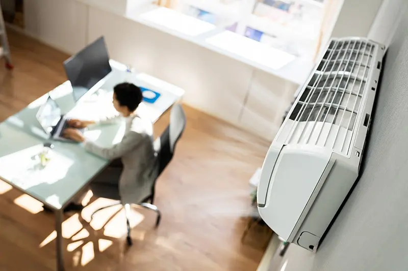 ductless unit blowing air next to an office worker