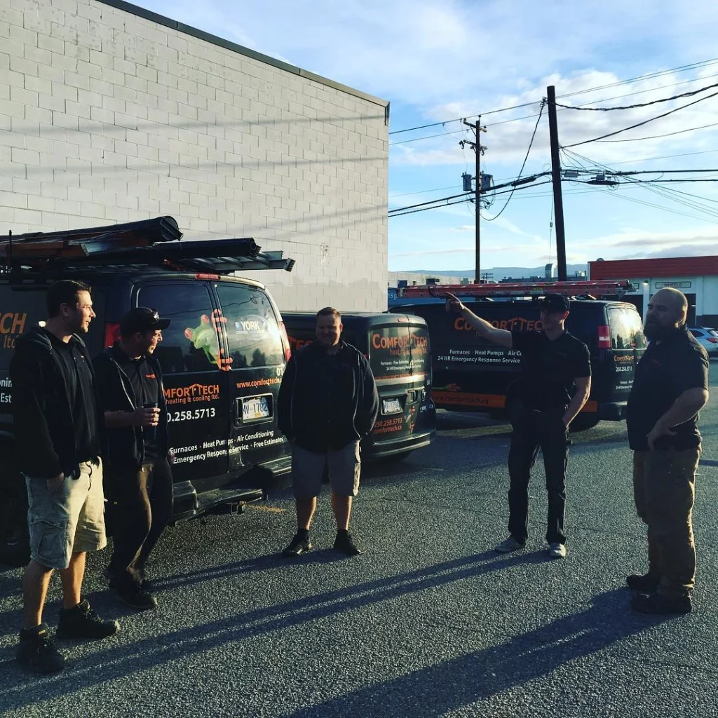 Comfort Tech team talking next to their vans