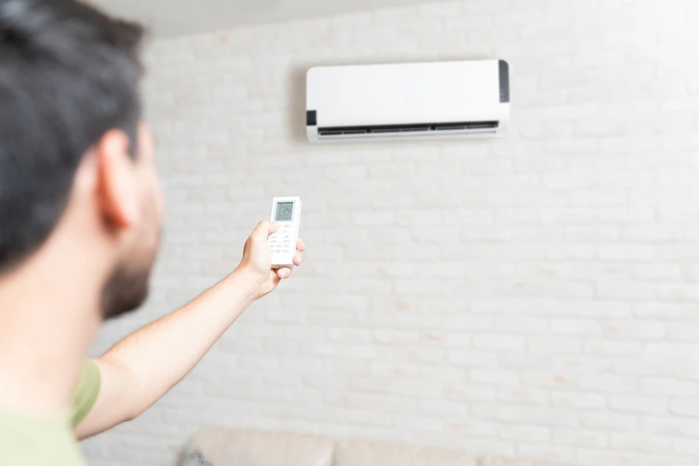 Man adjusting mini split temperature