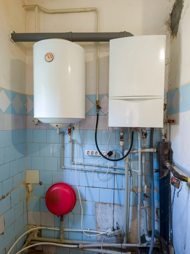 tank and tankless water heaters mounted on a wall