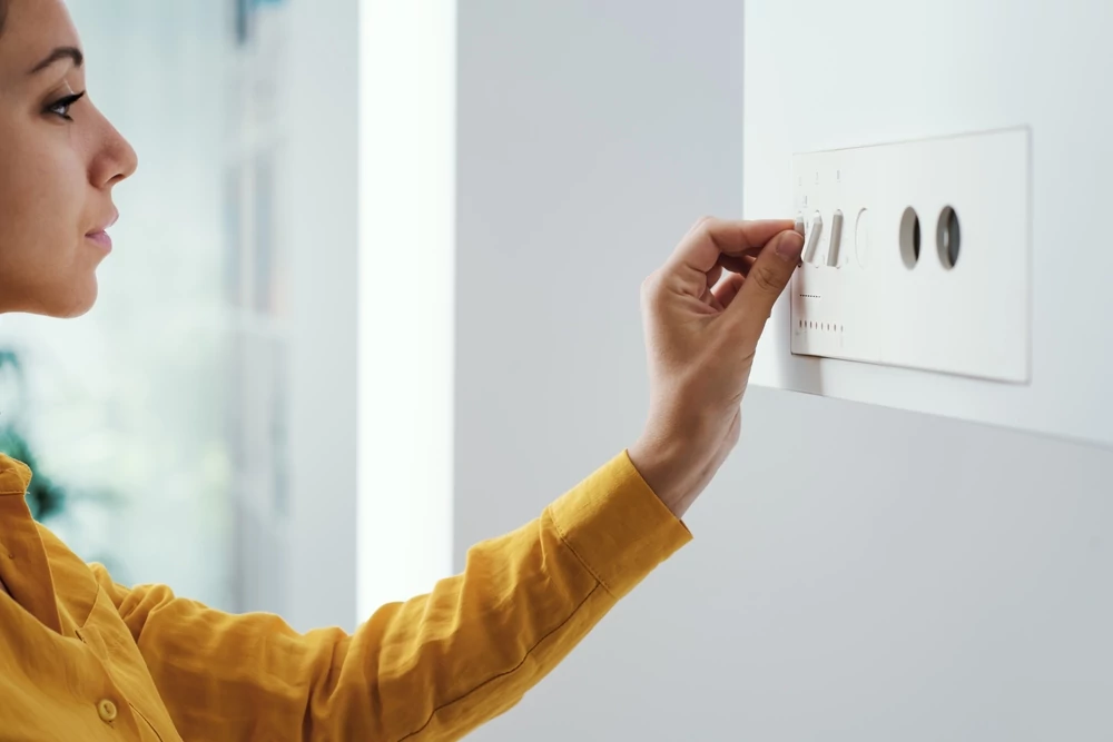 woman adjusting tankless water heater panel
