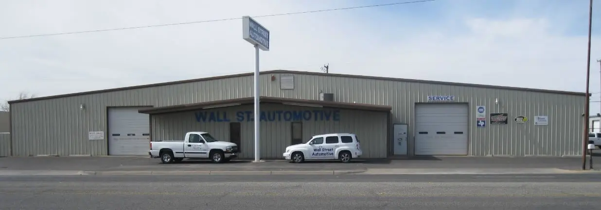Exterior of Wall Street Automotive shop with a white pickup truck and white SUV parked out front