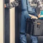 HVAC technician in work attire holding a tool box, ready to provide heating and air conditioning services.