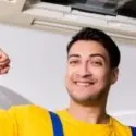 HVAC technician smiling and giving a thumbs-up, showcasing confidence and expertise in air conditioning maintenance and services.