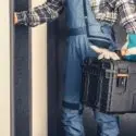HVAC technician in uniform holding a toolbox, ready to provide heating and air conditioning services in DeBary, FL.