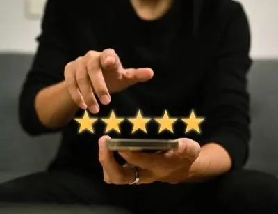 Person using smartphone to rate a service with five golden stars, symbolizing positive reviews for heating repair services.