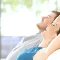 Couple relaxing indoors, enjoying comfortable air quality, emphasizing the importance of HVAC services for a pleasant home environment.