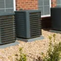 Central air conditioning units installed outside a home, surrounded by landscaping, illustrating HVAC solutions for improved home comfort and property value.