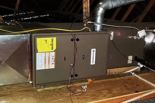 HVAC Company Searcy HVAC unit installed in an attic, with visible ductwork and wiring on a wooden platform.
