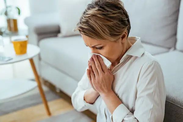 AC Installation and Indoor Air Quality: Improving Your Health - Woman blowing nose with tissue.