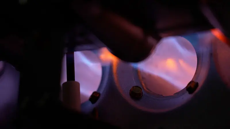 Close-up of heating system coil flames, highlighting efficient operation for Cotti-Johnson HVAC services in Taunton, MA.