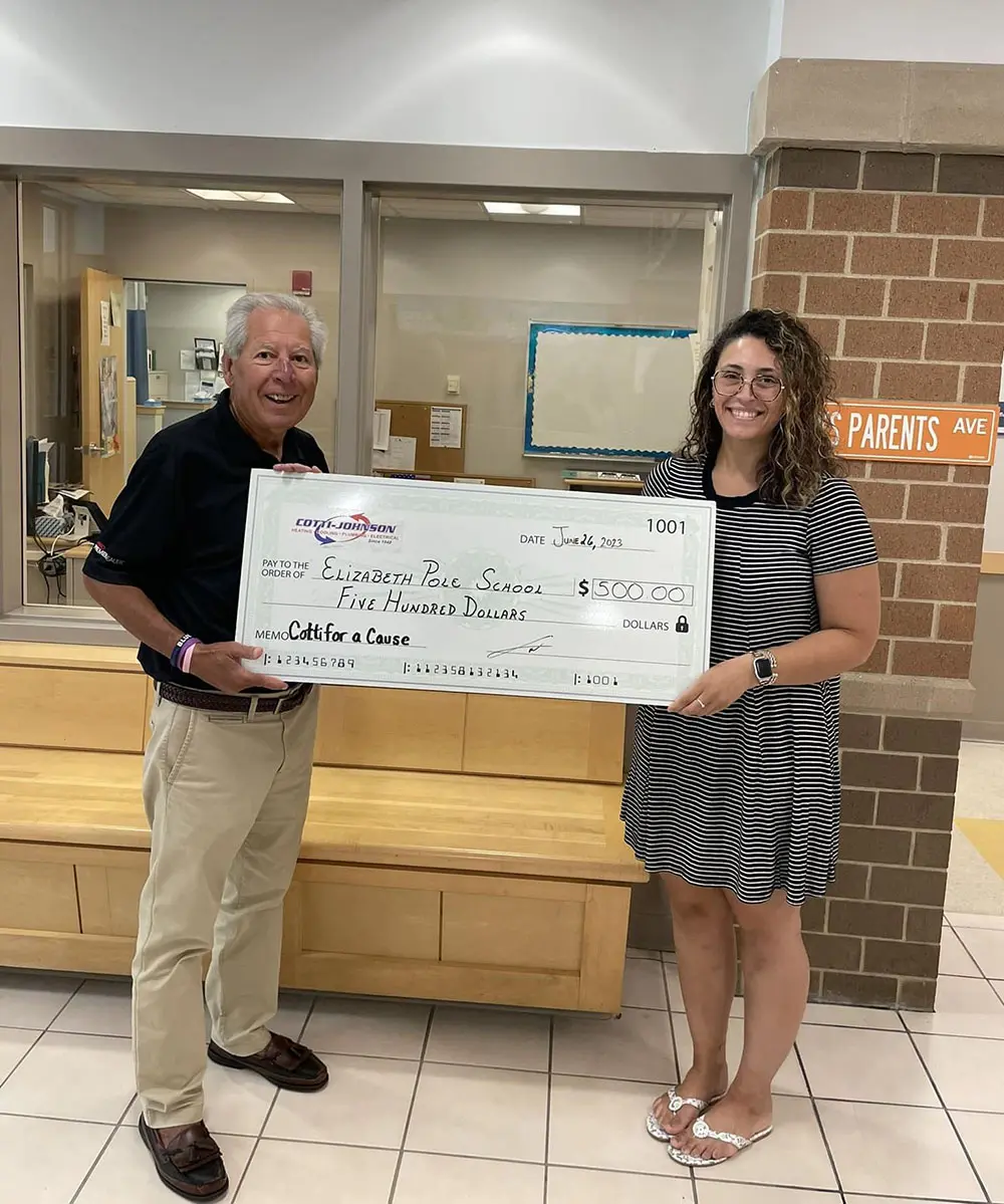 Vincent Boccalini from Cotti-Johnson presenting a $500 check to Alyssa Pimentel, Assistant Principal at Elizabeth Pole School, highlighting community support through the "Cotti Cares" initiative.