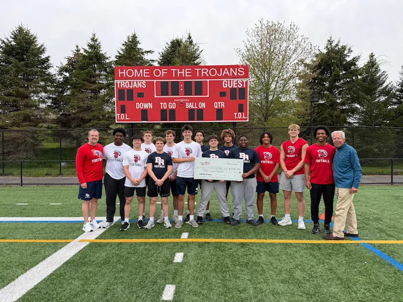 Cotti-Johnson representatives presenting check to Bridgewater-Raynham Trojans football team and coaches.