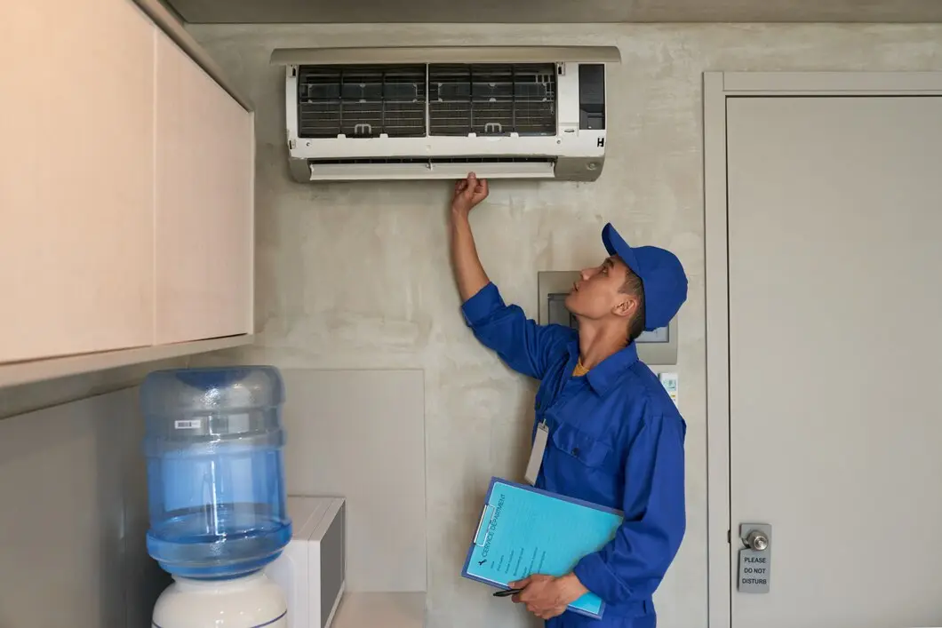 HVAC technician inspecting air conditioning unit during maintenance check, emphasizing importance of regular AC upkeep for energy efficiency and system longevity.