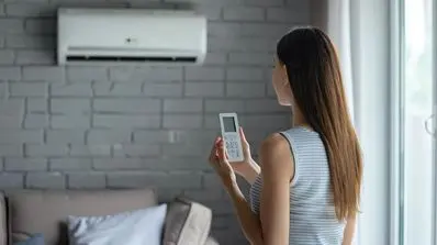 Woman using remote control to adjust air conditioning unit in modern living room, highlighting HVAC maintenance and comfort.