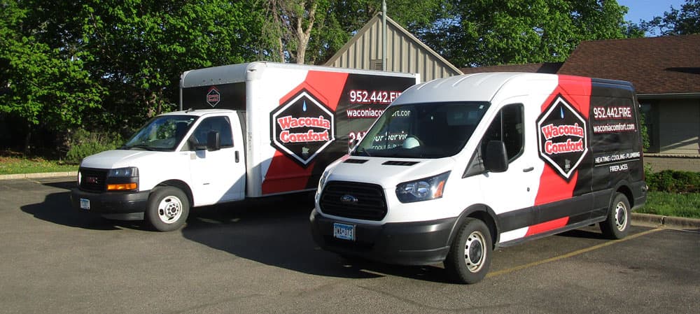 Waconia Comfort service vans parked outside, showcasing branding and contact information for HVAC services in Eden Prairie, MN.