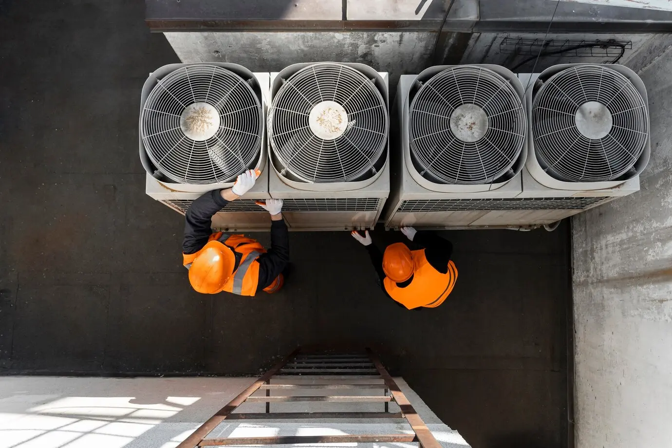 Technicians in safety gear performing maintenance on HVAC units, emphasizing professional HVAC services for home comfort and efficiency.