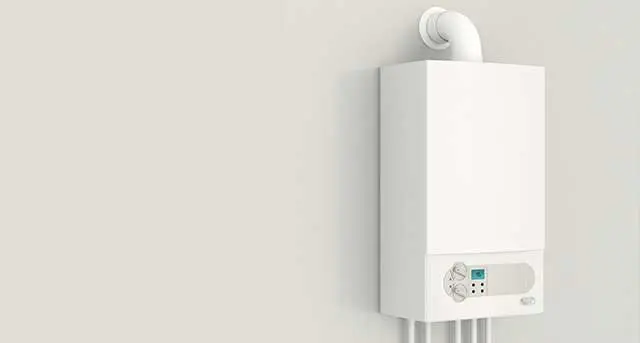 Tankless water heater installed on a wall, featuring a digital control panel and venting pipe, representing Jim Wagner Plumbing's installation services.