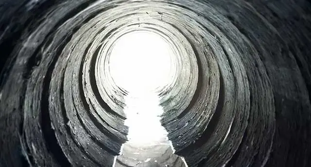 Underground sewer pipe interior with light at the end, illustrating sewer replacement services by Jim Wagner Plumbing, Inc. in West Chicago.