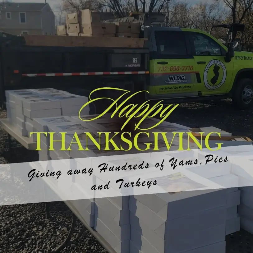 Happy Thanksgiving banner over tables filled with boxes, truck in background, promoting Jersey Trenchless LLC's annual turkey giveaway for local families.