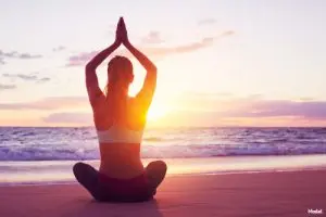 Woman doing yoga on the beach