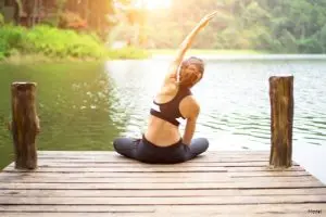 Woman sitting on a pier stretching