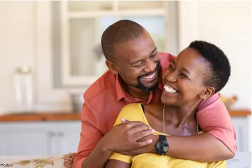 man hugging woman from behind and smiling