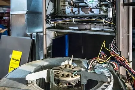 Close-up of the inner components of a furnace in Hemet, California, with visible wiring, fan, and mechanical parts. An AC technician's expertise is evident in the precise arrangement.