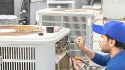 Technician repairing an air conditioning unit, emphasizing emergency AC repair services for residential comfort in Hemet, CA.