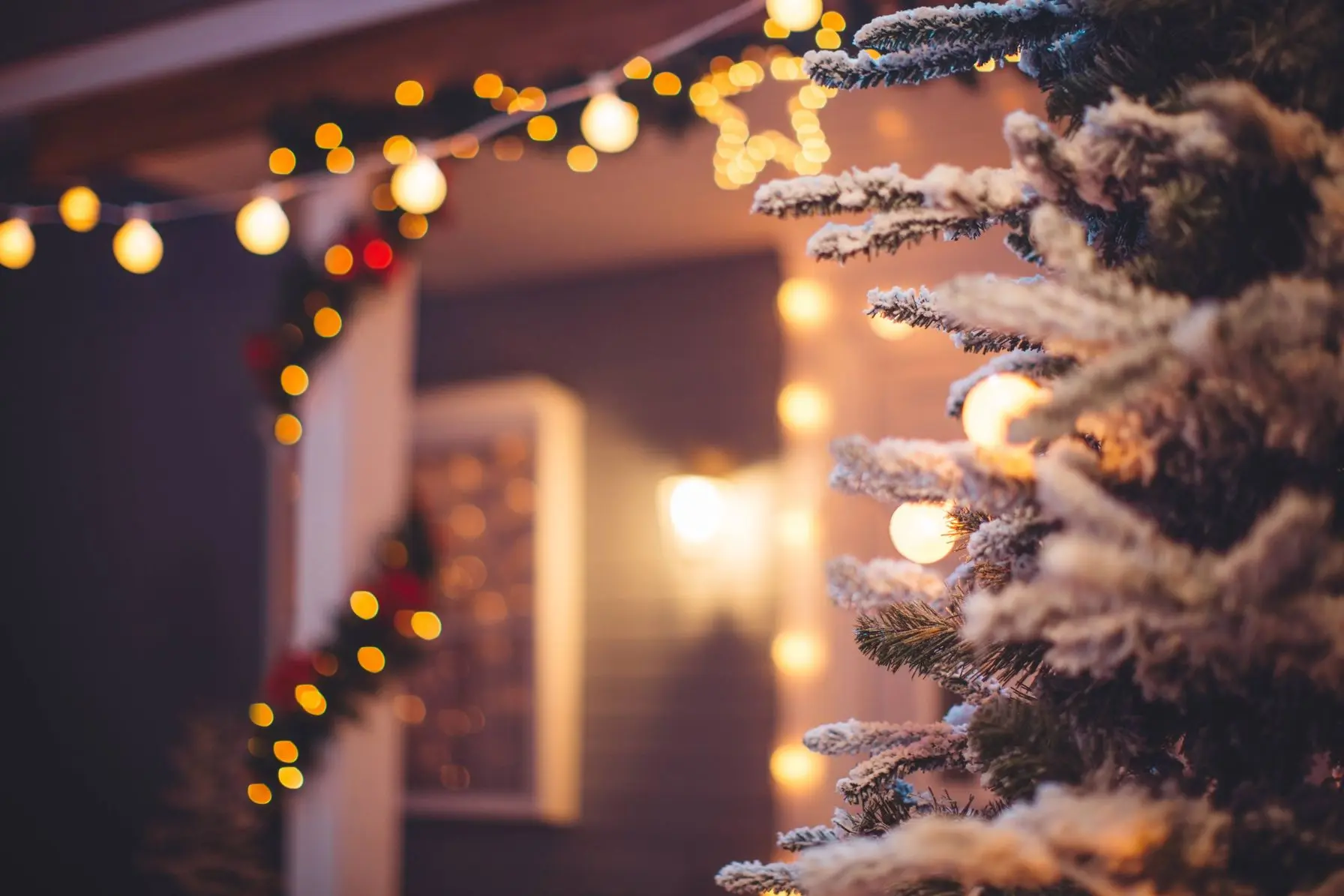 Decorated Christmas tree with lights and festive garland, creating a warm holiday atmosphere in a cozy home setting.