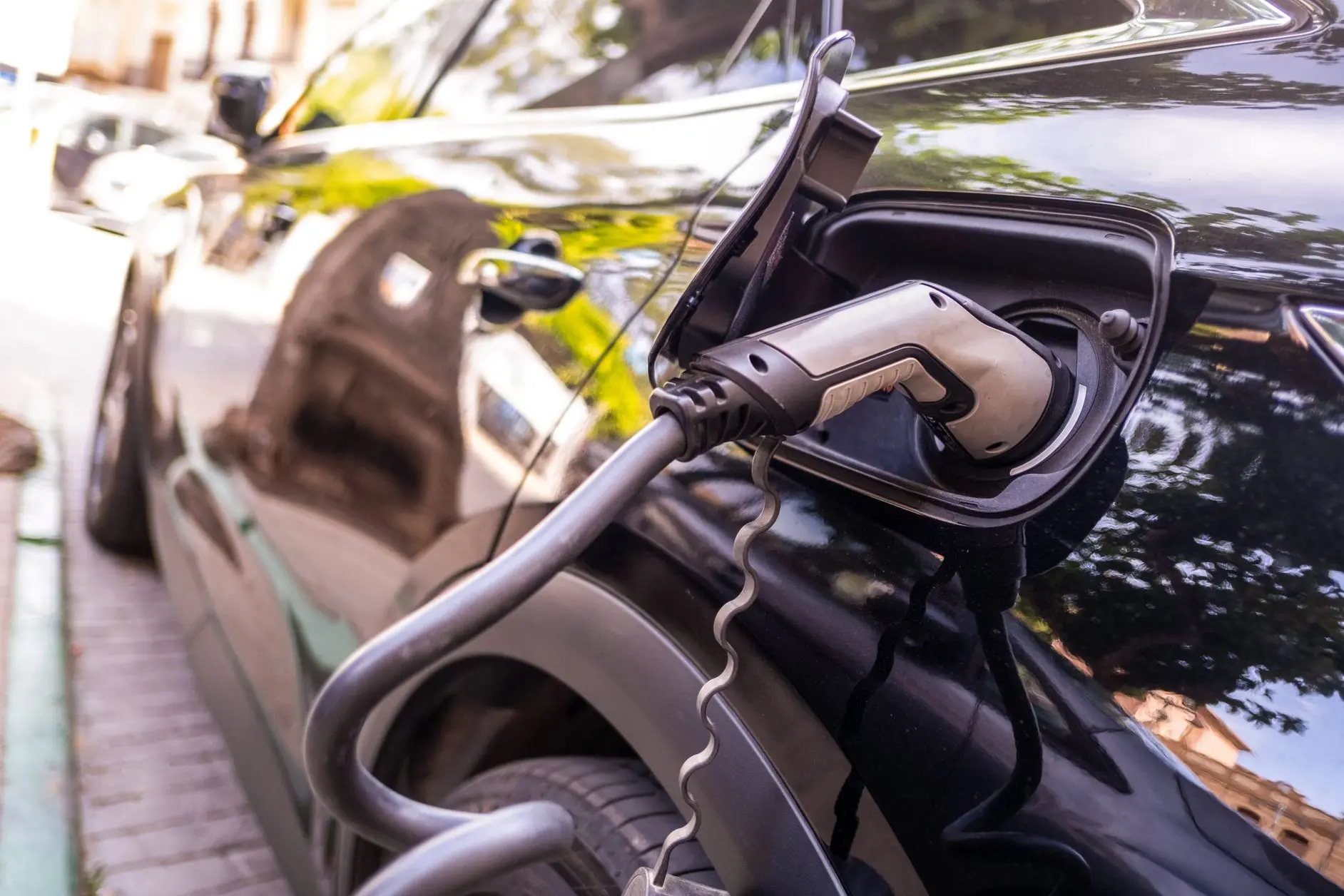 Electric vehicle charging station with a charging plug connected to a black car, highlighting home charging options for EV owners in Charlotte, NC.